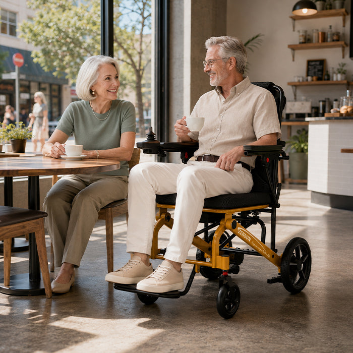 Senior couple with the ZENBON Flex Travel electric wheelchair in a home dining area