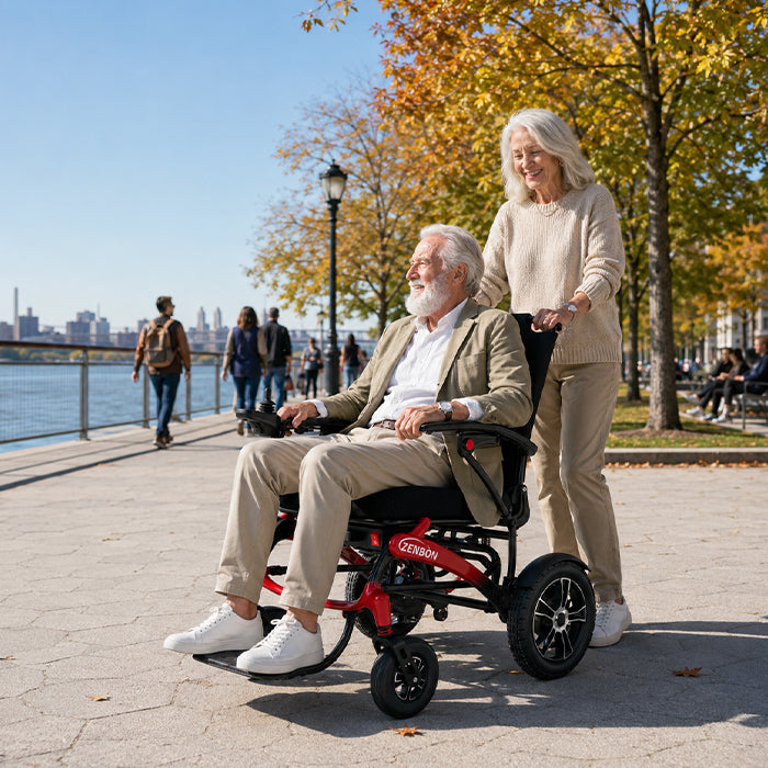 Couple using the ZENBON FoldX Pro electric wheelchair at a waterfront park