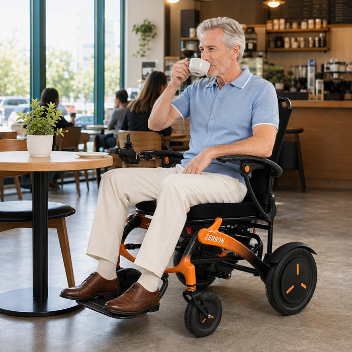 Adult seated in the ZENBON FoldX electric wheelchair at a dining table